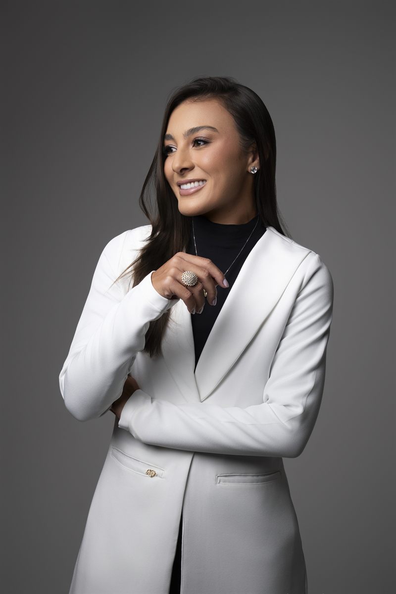 Dra. Ana Carolina de Castro sorrindo, em jaleco branco.