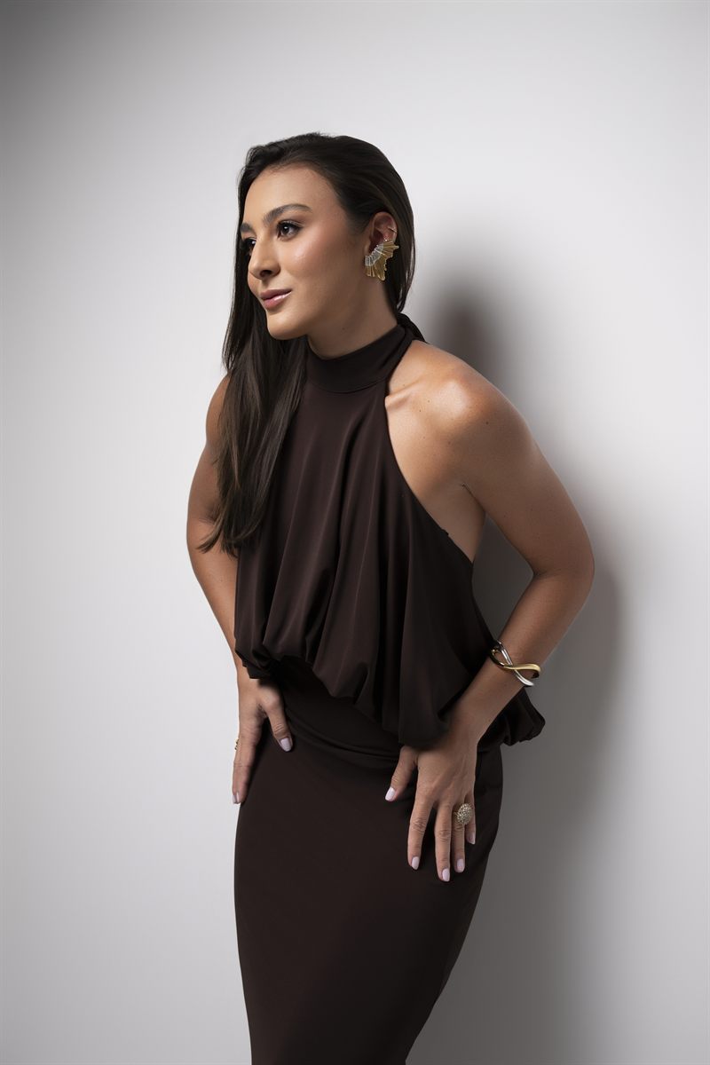 Dra. Ana Carolina de Castro em retrato editorial, com vestido marrom.